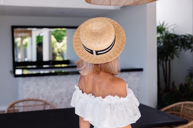 Mujer de pelo rubio bastante caucásico joven en la cocina al aire libre en la villa