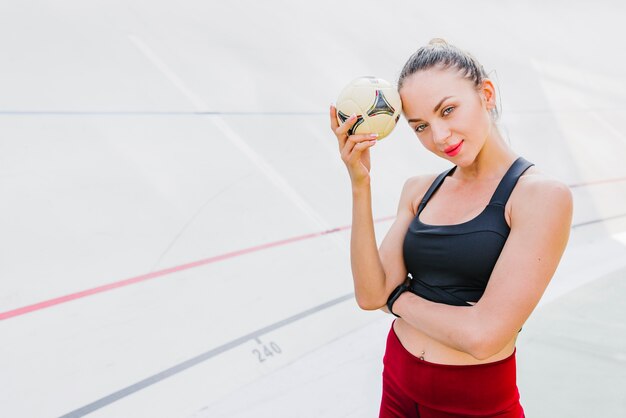 Foto gratuita mujer con pelota en mano frente a cámara