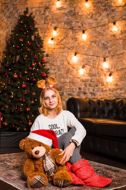 Mujer con peluche en noche de navidad