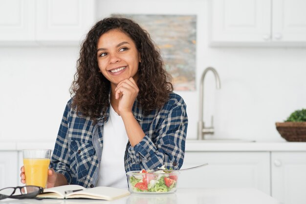 Mujer de pensamiento que sostiene un vaso de jugo