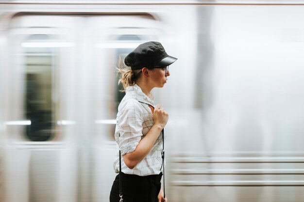 Mujer pensativa esperando un tren en una plataforma de metro