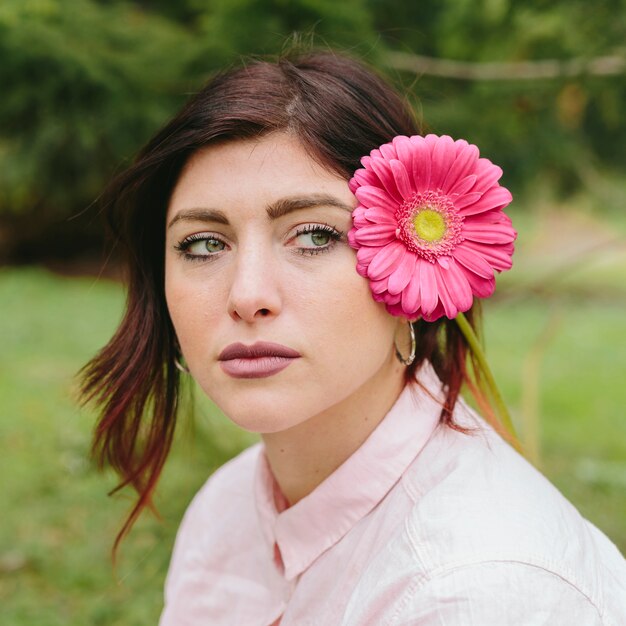 Mujer pensativa con flor en el pelo