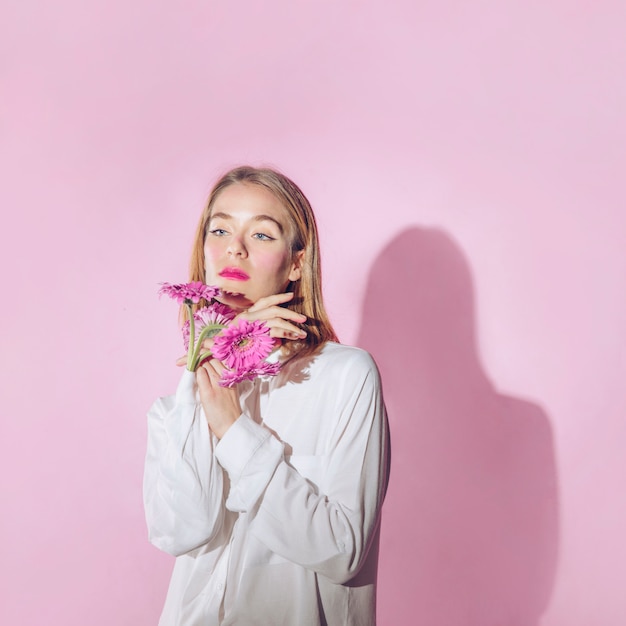 Mujer pensativa con flores en manga de camisa.