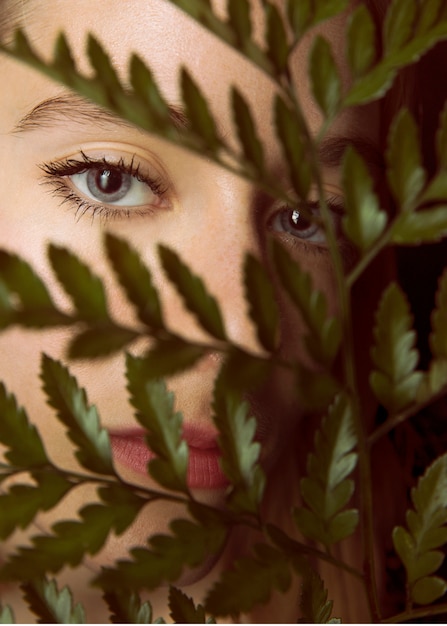 Mujer pensativa con rama de planta verde