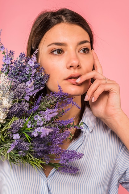 Mujer pensativa con ramo de flores.