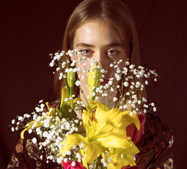 Mujer pensativa con ramo de flores.