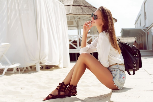 Mujer pensativa sentada en un día de playa