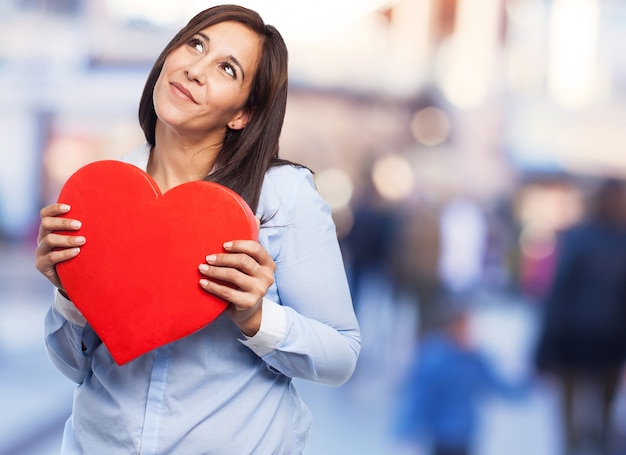 Mujer pensativa con un símbolo de amor