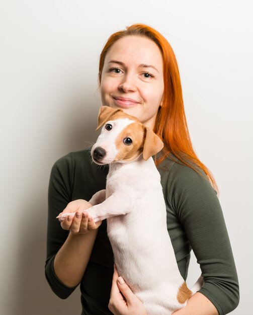 Mujer con pequeño terrier de Russel del enchufe