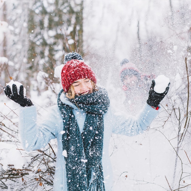 Mujer perdiendo juego de bolas de nieve en el bosque