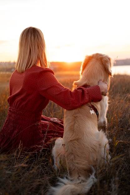 Mujer y perro al atardecer tiro completo