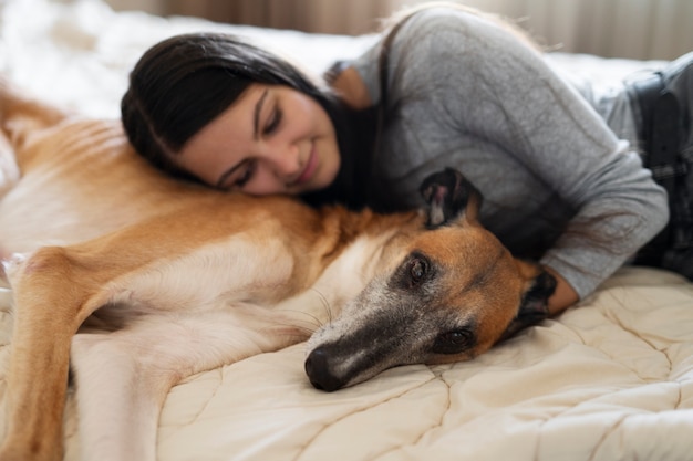 Mujer y perro de alto ángulo en la cama