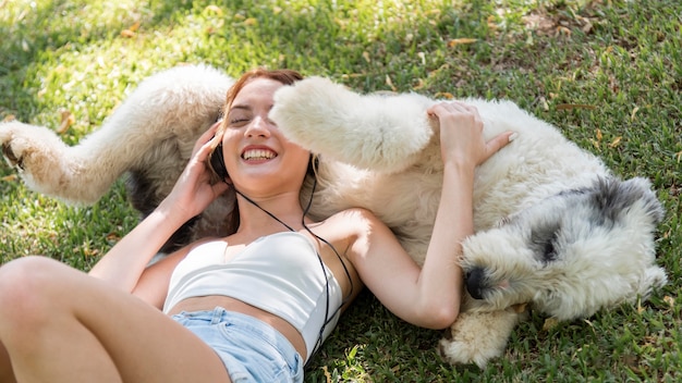 Mujer con perro escuchando música al aire libre