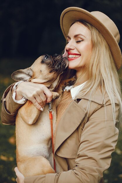 Mujer y perro juegan y se divierten en el parque de otoño.