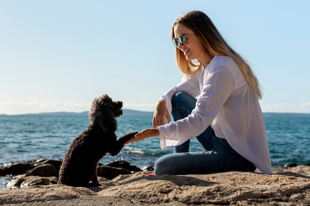 Foto gratuita mujer con perro en la playa