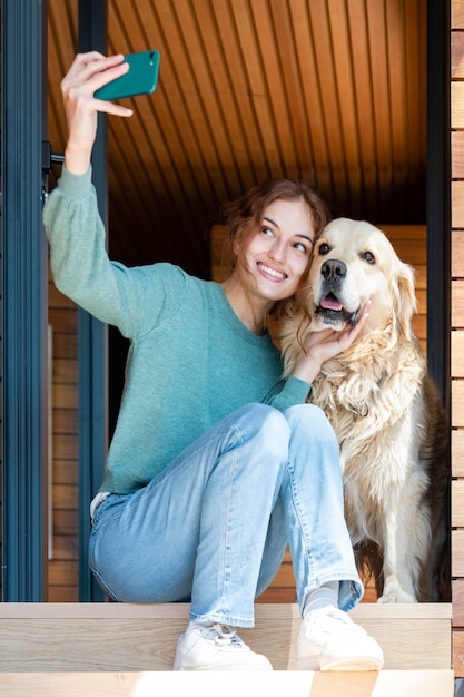 Mujer y perro tomando selfie full shot