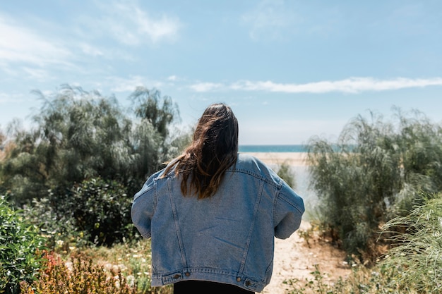 Foto gratuita mujer de pie en los árboles cerca de la playa tropical