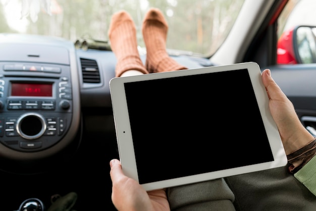 Foto gratuita mujer de pie en el asiento del pasajero con tableta