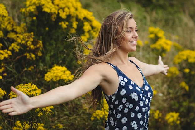 Mujer de pie con los brazos extendidos en pradera