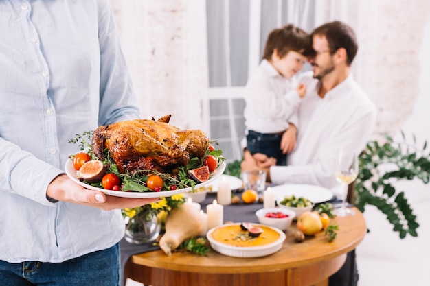 Mujer en pie de camisa con pollo al horno