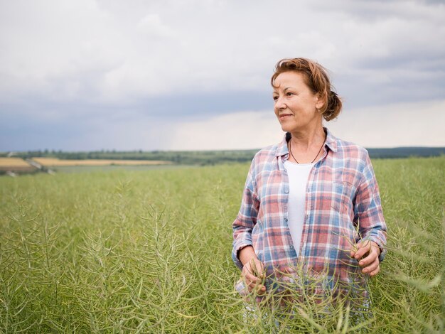 Mujer de pie en un campo con espacio de copia