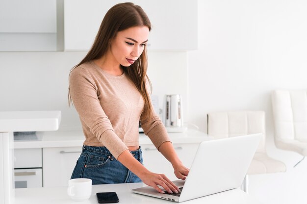 Mujer de pie en la cocina y el trabajo