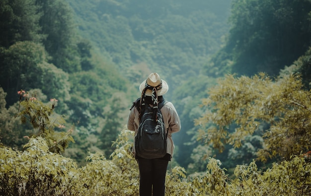 Foto gratuita mujer de pie en una colina mirando por encima de la selva