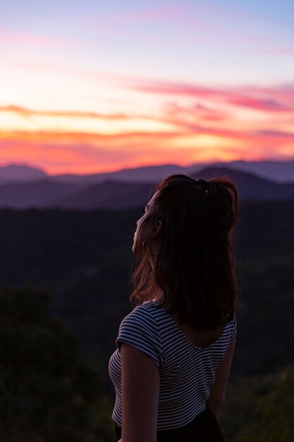 Mujer de pie delante de un hermoso fondo al amanecer