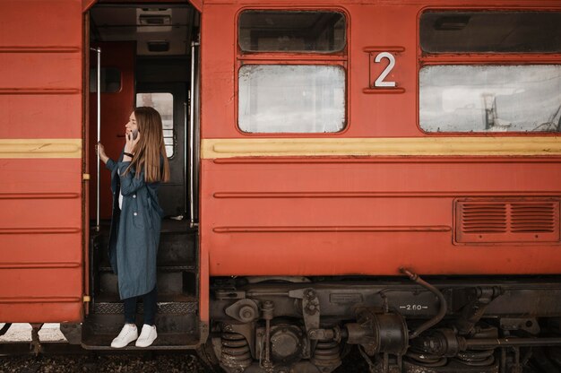 Mujer de pie en la entrada del tren y buscando a alguien