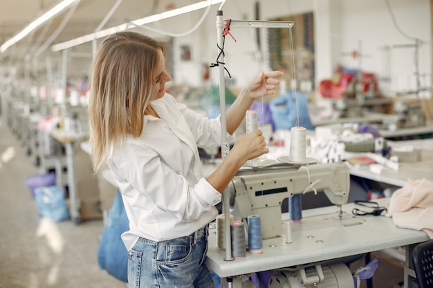 Mujer de pie en la fábrica con un hilo