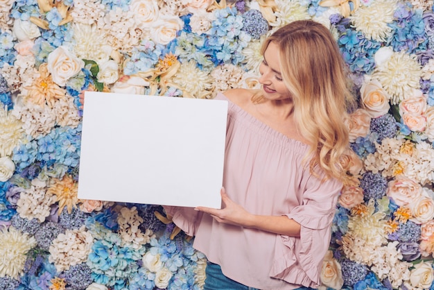 Foto gratuita mujer de pie con hoja de papel en blanco