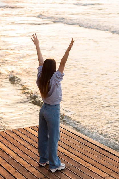 Foto gratuita mujer de pie junto al mar