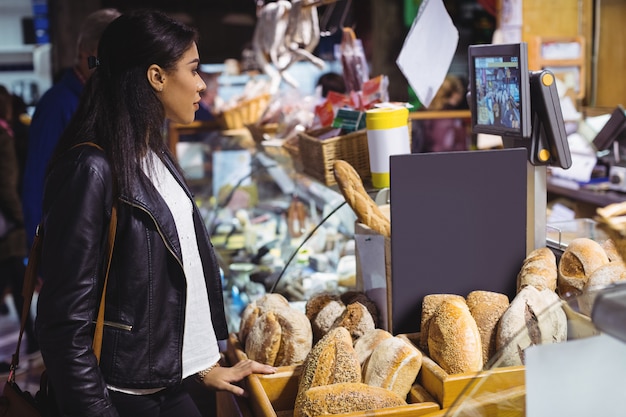 Mujer de pie en el mostrador de pan