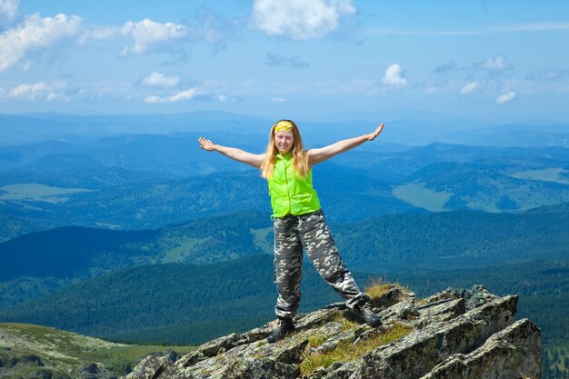 Mujer de pie en el pico de la montaña