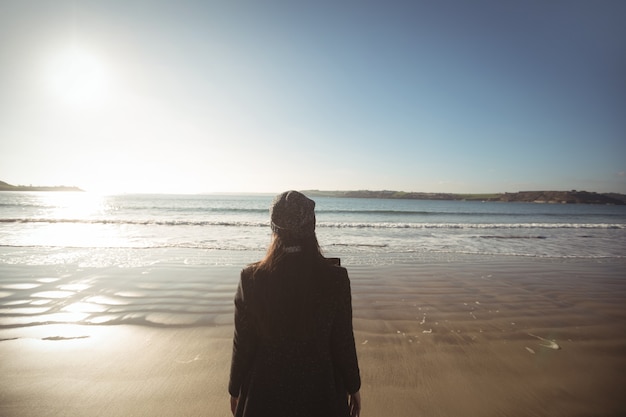 Foto gratuita mujer de pie en la playa durante el día