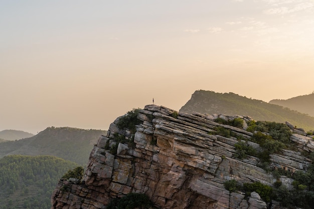 Mujer de pie en el punto más alto del mirador de Garbi durante la puesta de sol ubicado en Valencia España