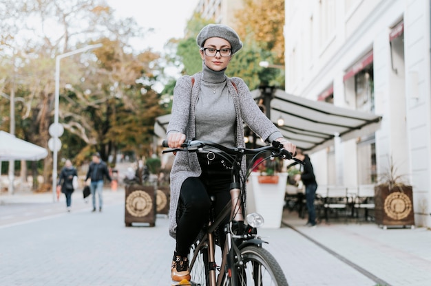 Mujer de pie sobre la bicicleta tiro largo