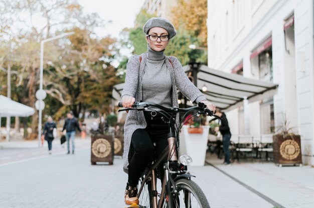 Mujer de pie sobre la bicicleta tiro largo