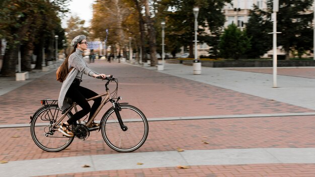 Mujer de pie sobre la bicicleta tiro largo