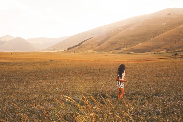 Mujer de pie sobre el campo de hierba marrón