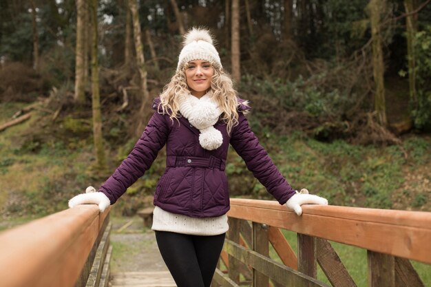 Foto gratuita mujer de pie sobre el puente en el bosque