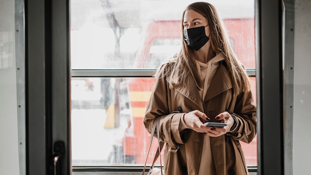 Mujer de pie en un tren y apartar la mirada