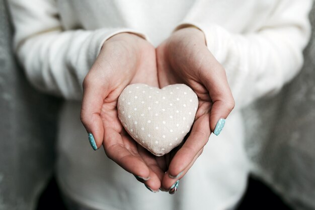 Mujer con una piedra con forma de corazón en las manos