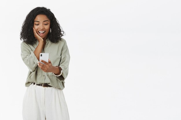 Mujer de piel oscura mirando smartphone