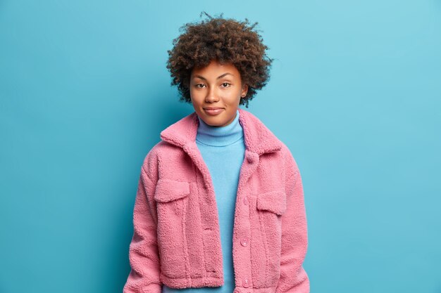 La mujer de piel oscura de moda tiene el pelo rizado