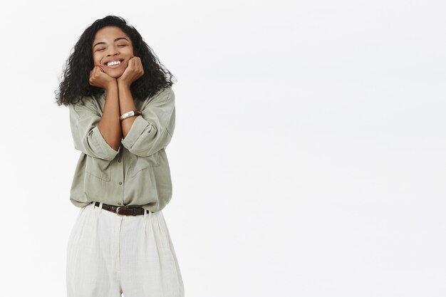 Mujer de piel oscura sonriendo encantada de alegría y felicidad