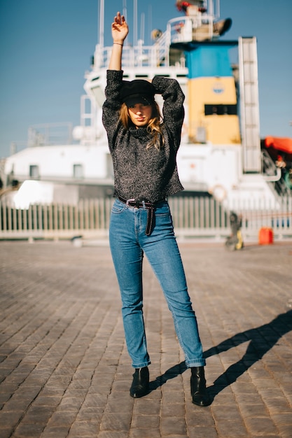 Mujer de pies enfrente de barco