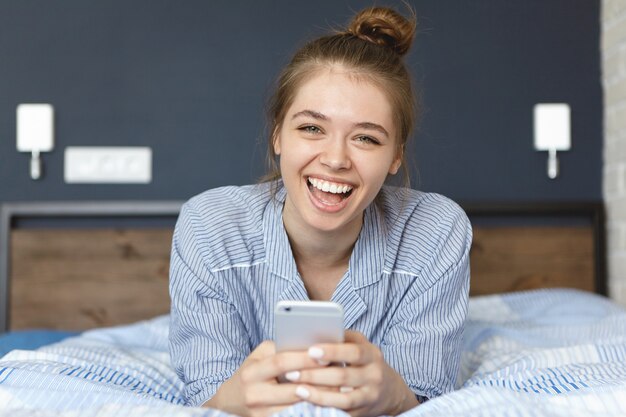 Mujer en pijama y sosteniendo smartphone