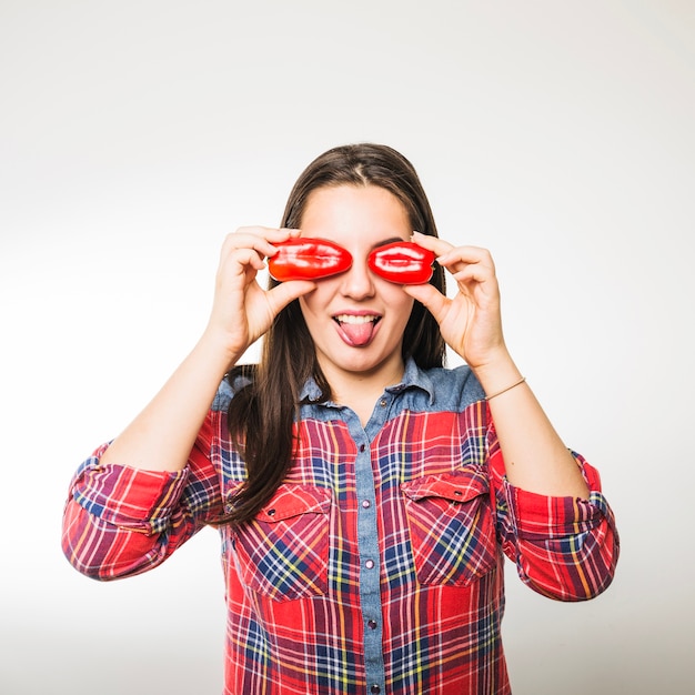 Mujer con pimientos mostrando lengua