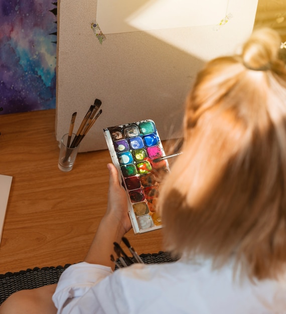 Mujer pintando con acuarela en estudio